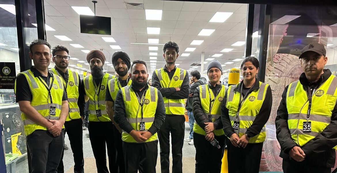 Group of AS Security personnel in high-visibility vests, standing together in a commercial setting, showcasing the company's commitment to professional security services in Melbourne.